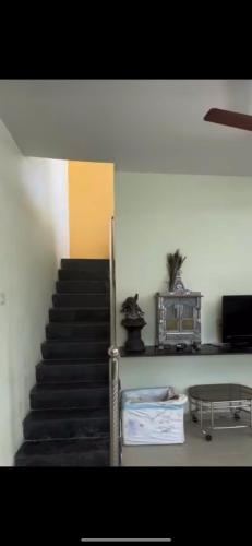 un escalier dans un bâtiment avec une table et une cage d'escalier dans l'établissement Ram Niwas Villa 3 Bedroom Home, à Vadodara