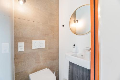 a bathroom with a toilet and a sink and a mirror at Bodensee Penthouse 23i - Seesicht - Billiard - Panorama Exklusive in Öhningen