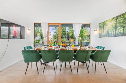 a dining room with a table and green chairs at Bodensee Penthouse 23i - Seesicht - Billiard - Panorama Exklusive in Öhningen