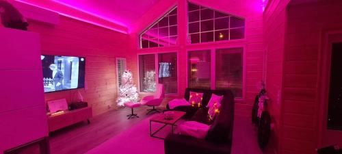 a living room with pink lighting and a couch at City Light in Tornio