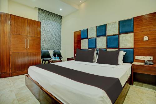 a bedroom with a large bed and two chairs at Super Townhouse Eastern View Formerly Vihaan Residency in Zirakpur
