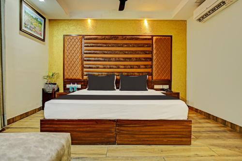a bedroom with a large bed with a wooden headboard at Super Townhouse Eastern View Formerly Vihaan Residency in Zirakpur
