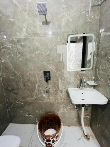 ein Badezimmer mit Waschbecken, Spiegel und Toilette in der Unterkunft Scropio In Dashrathpuri in Neu-Delhi