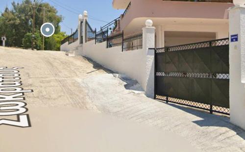 a house with a gate on the side of a road at Irida Suite in Salamís