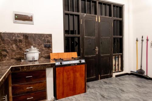 a kitchen with a counter with a stove and a door at Juula lagoon resort in Dodanduwa