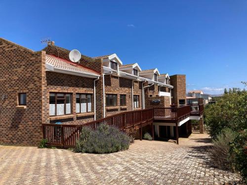 a brick building with a deck on a brick driveway at Net Net Holiday Home in Witsand