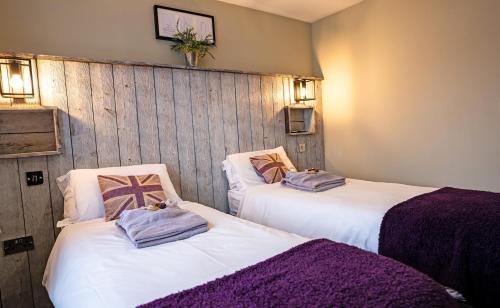 a room with two beds with purple blankets on them at Chestnut Meadow Country Park in Sidley