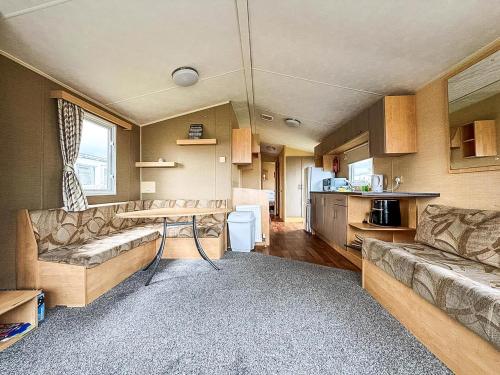 a living room with a couch and a table in a caravan at Homely, Dog Friendly Caravan At Sand Le Mere In Yorkshire Ref 71005O in Tunstall
