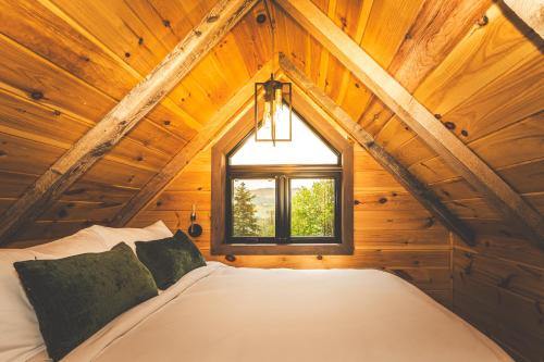 a bedroom with a bed in a wooden attic at Les Hébergements de l'Éternel in Saint-David-de-Falardeau