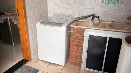 a washing machine in a kitchen next to a sink at Shalom - Conforto e Tranquilidade in Londrina