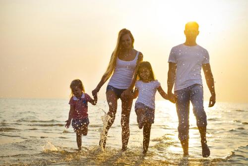 a family walking in the water on the beach at Homely, Dog Friendly Caravan At Sand Le Mere In Yorkshire Ref 71005O in Tunstall