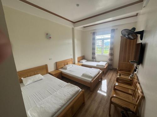 a room with two beds and a window at Hotel Hoàng Gia in Pan Linh