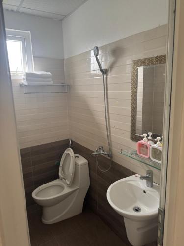 a bathroom with a toilet and a sink at Hotel Hoàng Gia in Pan Linh