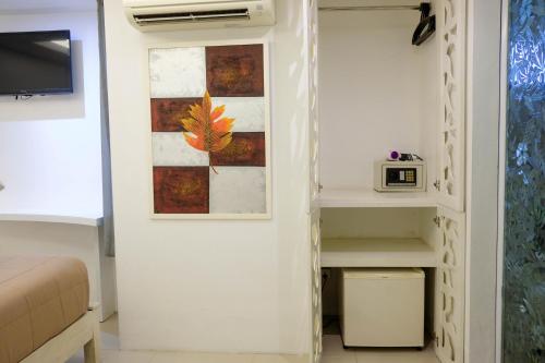 a bedroom with a closet with a bed and a tv at Baanpoon Apartment in Chaweng