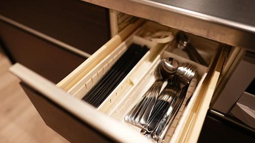 a kitchen utensils in a drawer in a microwave at HOTELHOUSE Nekogoya Shindohigashi 新道東 in Sapporo