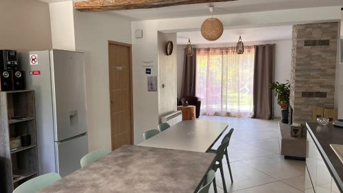 een keuken en eetkamer met een tafel en stoelen bij La ferme de Coron in Belley