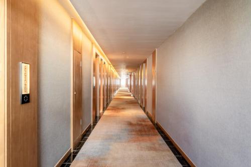 a hallway with a long aisle in a building at SSAW Hotel Guiyang Beijing Road Guiyi Subway Station in Guiyang