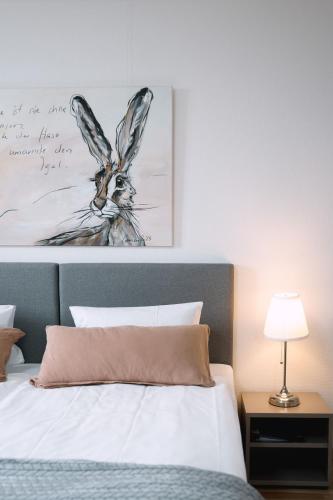 a bedroom with a bed with a painting on the wall at Hotel & Restaurant Nollen in Hosenruck