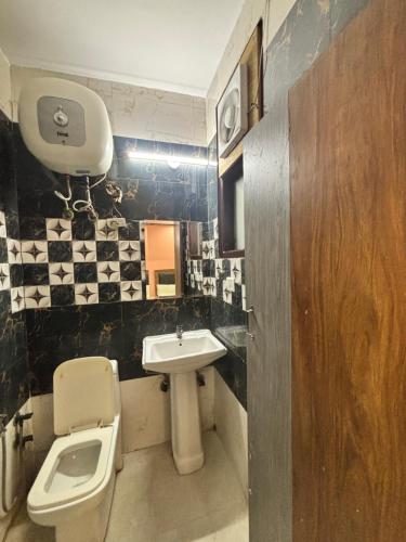 ニューデリーにあるClassic Harmony Innのトイレと洗面台のある小さなバスルーム