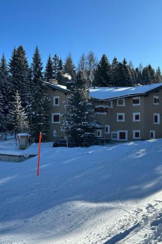 a snow covered parking lot in front of a building at Apartment Ferienwohnung Selva by Interhome in Lenzerheide