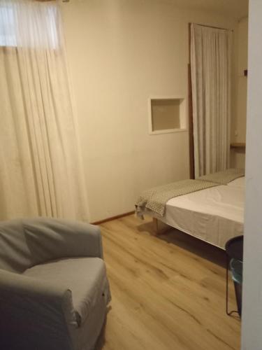 a room with two beds and a chair and a couch at Golden Spa Hotell in Eskilstuna