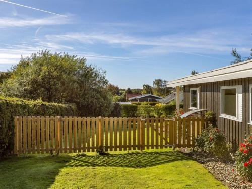 Holiday Home Quanna - 450m from the sea by Interhome في Hejlsminde: سور خشبي في ساحة بجوار منزل