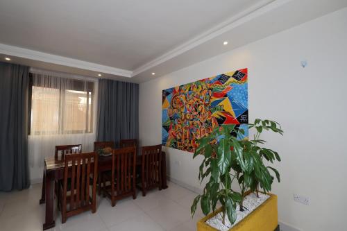 a dining room with a painting on the wall at Bon Bini Residence in Kampala