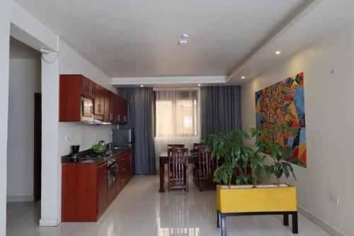 a kitchen and living room with a plant in it at Bon Bini Residence in Kampala