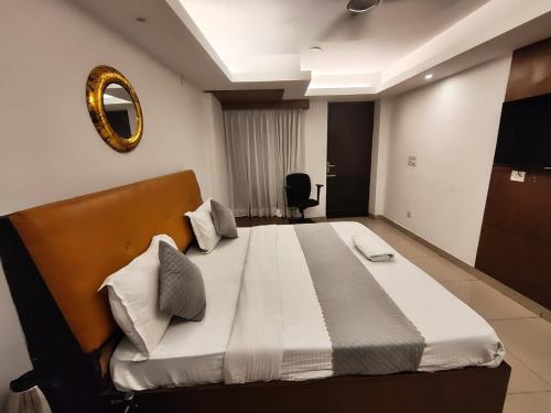 a bedroom with a large bed with a mirror on the wall at Hotel Iconic Ganga Ram hospital in New Delhi