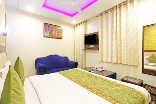 a hotel room with a bed and a blue chair at Hotel Iconic Ganga Ram hospital in New Delhi