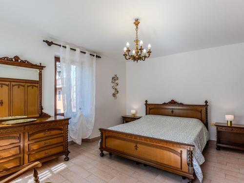 a bedroom with a bed and a dresser and a chandelier at Holiday Home Papaveri e Papere by Interhome in Piano Porlezza