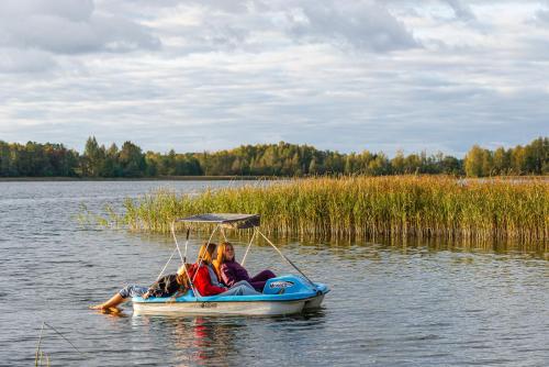 a group of people riding on a boat on a lake at Namelis ant vandens "Giliaus namelis" in Tytuvėnai