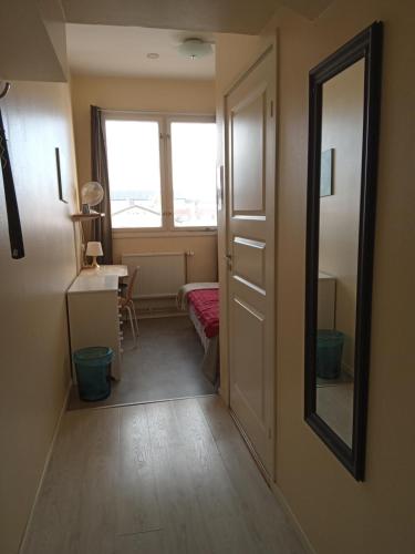 a room with a hallway with a mirror and a window at Golden Spa Hotell in Eskilstuna