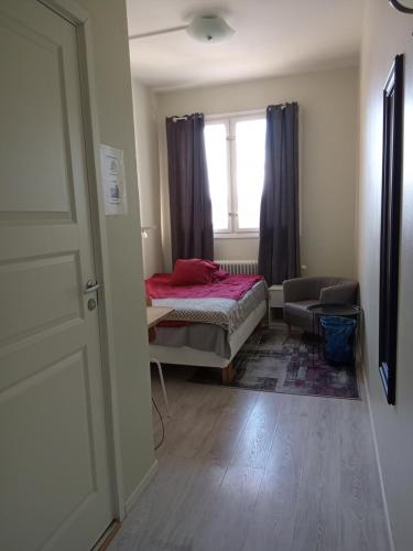 a small bedroom with a bed and a window at Golden Spa Hotell in Eskilstuna