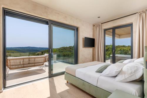 a bedroom with a bed and a balcony with sliding glass doors at Casa Mayren Romantic Villa pool and Spa in Kunj