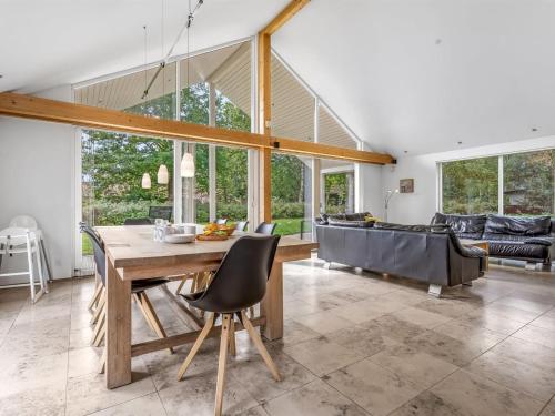 a dining room with a table and a couch at Holiday Home Talitha - 40m from the sea by Interhome in Marielyst