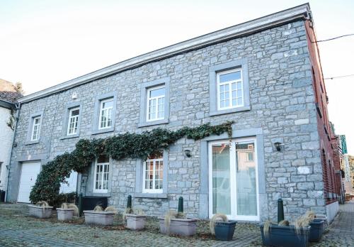 a stone building with potted plants in front of it at Maison Aimée Cottage 9 people in Rochefort