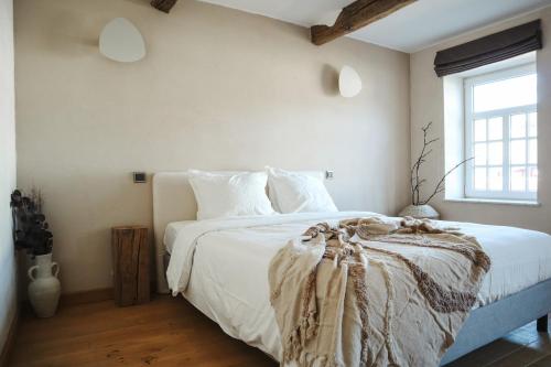 a bedroom with a bed with white sheets and a window at Maison Aimée Cottage 9 people in Rochefort