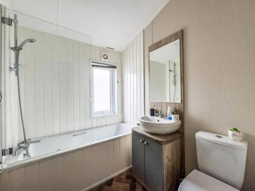 ein Badezimmer mit Waschbecken, Badewanne und Toilette in der Unterkunft Stunning Lodge At Seaview Holiday Park In Kent Ref 47012Pb in Whitstable