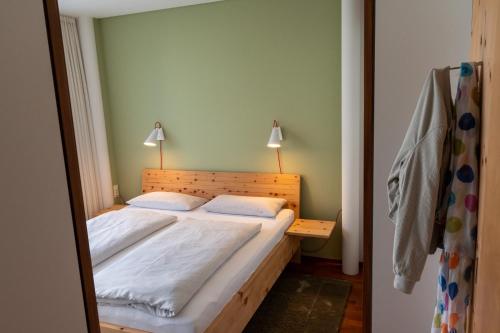 Un dormitorio con una cama con dos almohadas blancas. en Lebensfreude, en Dornbirn