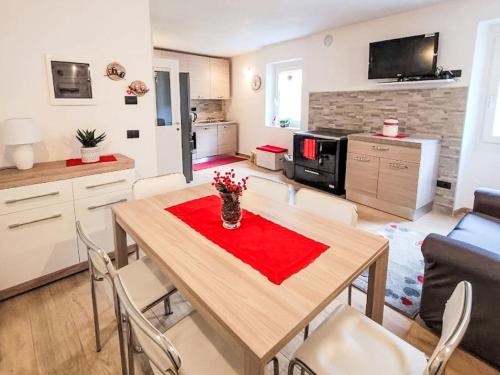 a kitchen and living room with a wooden table and chairs at Apartment Festér by Interhome in Santi di Daone