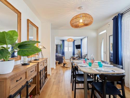 a dining room and living room with a table and chairs at Holiday Home Maison Edgar Luce by Interhome in Agon Coutainville