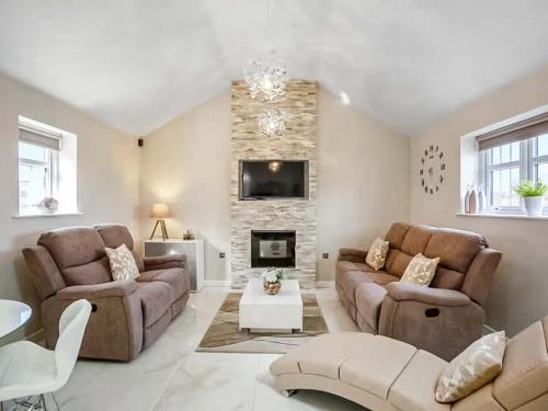 ein Wohnzimmer mit zwei Sofas und einem Kamin in der Unterkunft Peewit Cottage-Ukc6986 in Castleside