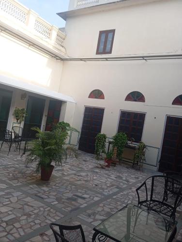 a courtyard with chairs and tables and a building at Hotel Heritage Suite Hari Mahal in Jaipur