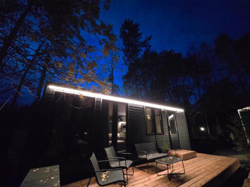 a tiny house with lights on a deck at night at Aava Riverside in Rovaniemi