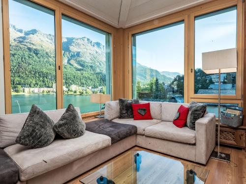 a living room with a couch and large windows at Apartment Chesa Spuonda Verde 2-5 by Interhome in St. Moritz