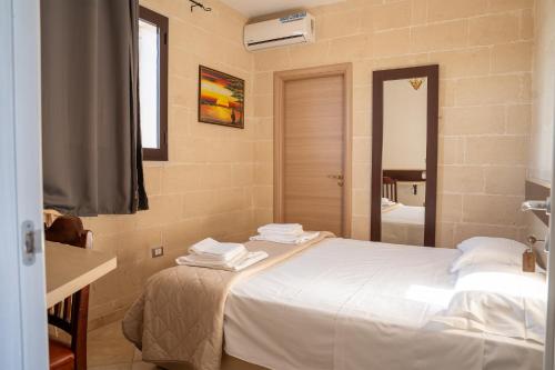 a bedroom with a white bed and a mirror at Tenuta delle Marene - Only Adults in Torricella