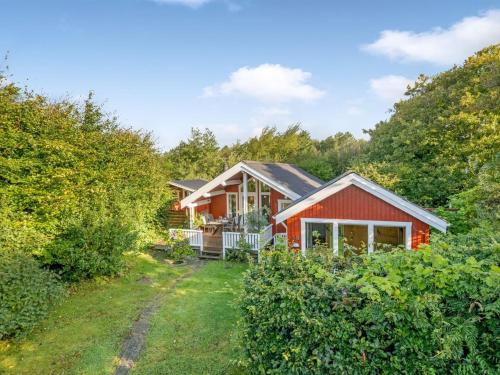 a red house in the woods with a yard at Holiday Home Elea - 450m to the fjord by Interhome in Skalstrup