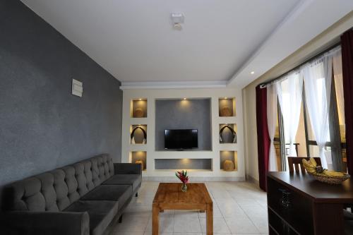 a living room with a couch and a tv at Bon Bini Residence in Kampala