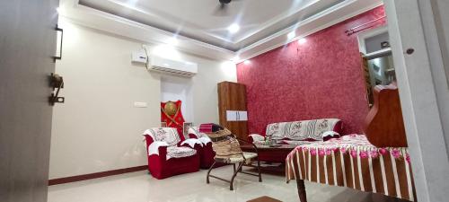a room with a table and chairs and a red wall at Rajawat house in Tonk City